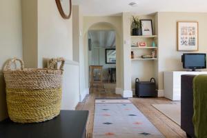 a living room with a wicker basket sitting on a table at Malvern hills, beautiful garden flat Twohundredandseven in Malvern Wells