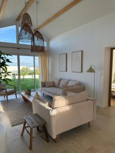 a living room with a couch and a table at Jolie Villa avec bain balnéothérapie in Colombiers