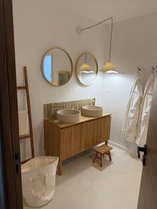a bathroom with two sinks and two mirrors at Jolie Villa avec bain balnéothérapie in Colombiers