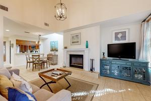 ein Wohnzimmer mit einem TV und einem Kamin in der Unterkunft 4406 Windswept in Kiawah Island