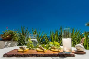 a table with a wooden cutting board with a glass of milk at Pounda Paou in Metókhion