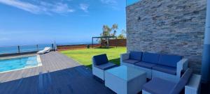 a patio with two blue chairs and a swimming pool at TAHITI - Villa Green M in Punaauia