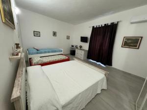 a bedroom with two beds and a window at Stanza Globo in Nulvi +6 photos