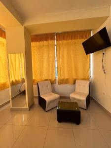 a living room with two chairs and a table at Hotel Paraiso L & M in Huánuco