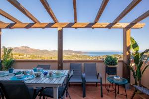 een tafel en stoelen op een balkon met uitzicht op de oceaan bij Pandora Sea View by Solturelba in Capoliveri