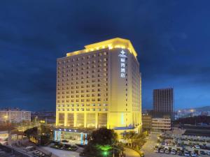 a tall yellow building with lights on top of it at Shenzhen Longgang Rivan Hotel in Longgang