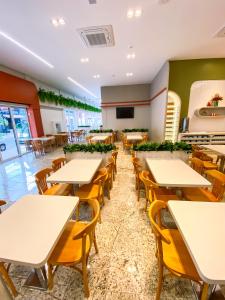 uma sala de jantar com mesas e cadeiras em um restaurante em Hotel Zata - Premium em Criciúma mais 75 fotografias