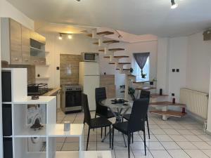 a kitchen and dining room with a spiral staircase in a room at Átrium Dunaujváros in Dunaújváros