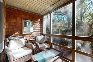 a screened in porch with chairs and a table at Mariner's Watch 4236 in Kiawah Island
