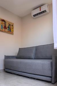 a gray couch in a room with a air conditioner at Coral - Praia da Pipa in Pipa
