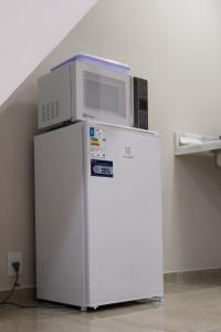 a microwave sitting on top of a refrigerator at Coral - Praia da Pipa in Pipa