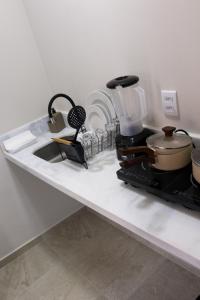 a kitchen counter with a stove and a sink at Coral - Praia da Pipa in Pipa