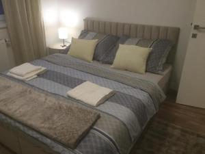 a large bed with two pillows and two towels on it at A2 Apartman in Sopron