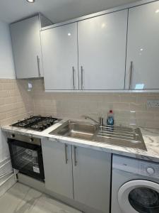 a kitchen with a sink and a washing machine at Two Bedrooms Bungalow Garden Lodge in Aveley