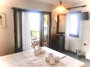 a bedroom with a white bed with two pillows on it at Pounda Paou in Metókhion