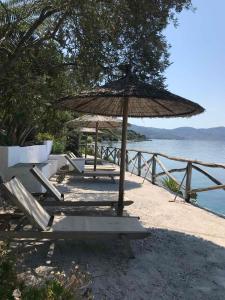a group of chairs and an umbrella on the beach at Pounda Paou in Metókhion