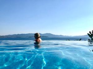 a person in a swimming pool in the water at Pounda Paou in Metókhion