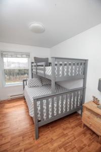 Un dormitorio con dos literas y suelo de madera. en Le 1717 Lakeside cottage, en Sainte-Lucie-de-Doncaster