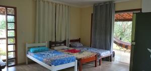 a bedroom with two beds in a room at CHALÉ LUZIMAREs 01 in Ilhéus