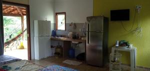 a kitchen with a stainless steel refrigerator and a sink at CHALÉ LUZIMAREs 01 in Ilhéus