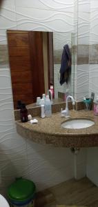 a bathroom counter with a sink and a mirror at CHALÉ LUZIMAREs 01 in Ilhéus +12 photos
