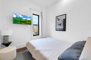 a white bedroom with a bed and a window at Stylish 3Bd Heart of Park Slope in Brooklyn