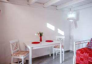 a white table with two chairs and a vase with flowers at Aristomenis House Lentas in Lentas