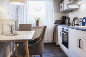 a kitchen with a table and a dining room at Ferienwohnung Wiesenzauber - Ruhige Lage am Stadtrand von Leer & Rhauderfehn in Rhauderfehn +25 photos