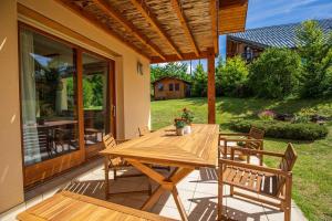 a wooden table and chairs on a patio at Les Roses du Vercors Maison Villard de Lans in Villard-de-Lans