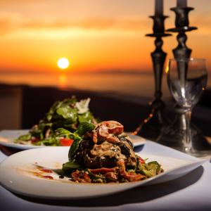 a plate of food on a table with a salad at Andromeda Villas & Spa Resort in Imerovigli