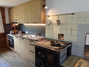 a kitchen with a sink and a stove top oven at Ferienwohnung Berktold in Bizau
