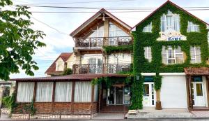 a house covered in ivy on a street at Racu in Komrat