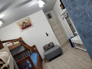 a bedroom with a bunk bed and a chair at Suítes Sol do Guarujá in Guarujá