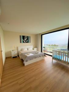 Un dormitorio con una cama y una ventana grande. en Esperança Terrace, en Braga