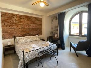 a bedroom with a bed and a brick wall at Castello D'Alcontres Guest House 3 stelle in Nizza di Sicilia