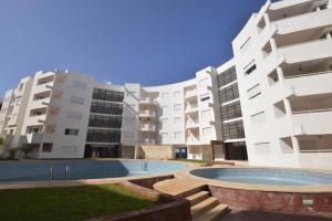 un complejo de apartamentos con piscina frente a un edificio en BOUZNIKA AJ, en Bouznika