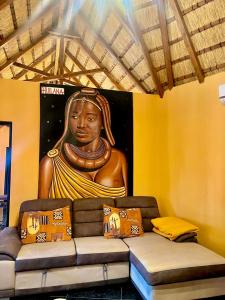 a mural of a statue of a woman on a wall at Kimbo do Soba Resort in Sá da Bandeira
