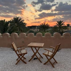 einen Picknicktisch und zwei Stühle auf einer Terrasse in der Unterkunft Al Jalilain Inn in Nizwa + 20 Fotos