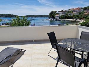 un balcone con tavolo e sedie e vista sull'acqua di Apartmani Neda a Rab