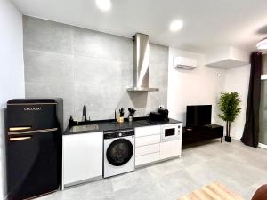 a kitchen with a washer and a sink and a stove at Valencia Comfort Stay Near Metro, 2 Bed, 1 Bath in Valencia