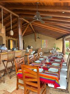 a dining room with a long table with chairs and a ceiling at Casamar, beach front estate on Troncones Point in Troncones +18 photos