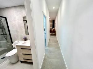a bathroom with a toilet and a sink and a mirror at Valencia Comfort Stay Near Metro, 2 Bed, 1 Bath in Valencia +26 photos