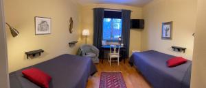 a bedroom with two beds and a window at Hotell Laurentius in Strängnäs