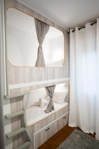 a small bedroom with a bunk bed with a mirror at La posada in Porriño