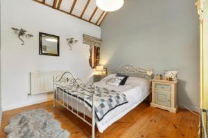 a bedroom with a metal bed and a wooden floor at Foxes Walk - Rural Views Rustic Charm in Templeton