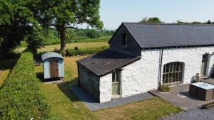 a small white building with a black roof at Foxes Walk - Rural Views Rustic Charm in Templeton