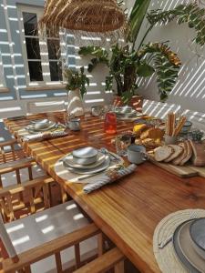 een houten tafel met borden met eten erop bij Herdade D’ Amoreira Aljezur in Aljezur