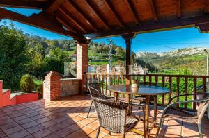 a patio with a table and chairs on a balcony at Casa la fuente in Vibaño