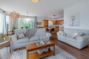 a living room with a couch and a table at 5 Chambres et 3 salles de bain avec Spa, vue, foyer et plus in Petite-Rivière-Saint-François