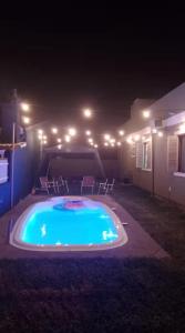 a swimming pool at night with lights in a yard at Luciene in Xangri-lá